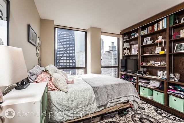 260 East Chestnut Street, Unit 3201 Chicago, IL 60611 - Photo 9 of 15 a bedroom with a bed and a book shelf