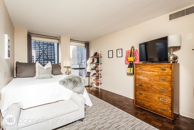 260 East Chestnut Street, Unit 3201 Chicago, IL 60611 - Photo 10 of 15 a bedroom with a bed and a flat screen tv