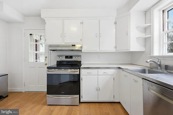 a kitchen with granite countertop white cabinets and appliances