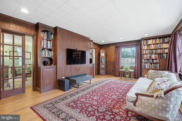 a living room with furniture large window and flat screen tv