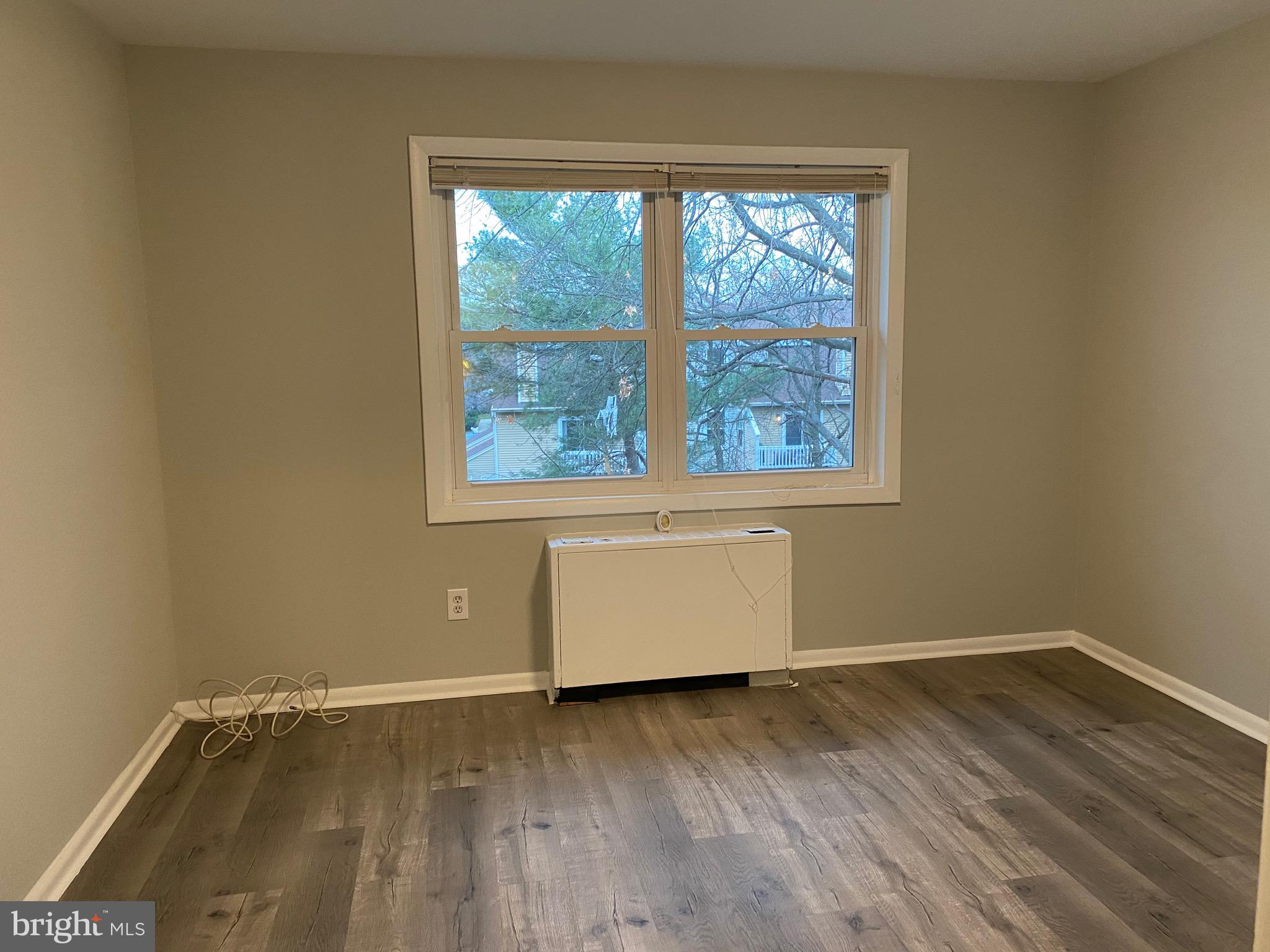 4256 Buckman Road, Unit 27 Alexandria, VA 22309 - Photo 14 of 30 an empty room with wooden floor and windows
