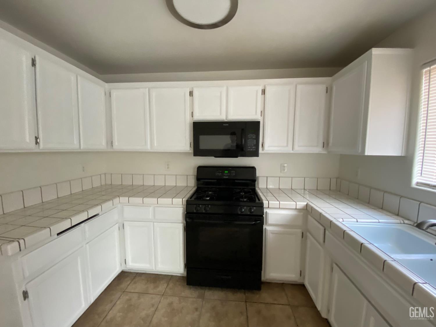 Undisclosed Address Bakersfield, CA 93307 - Photo 13 of 34 a kitchen with a sink and a stove top oven