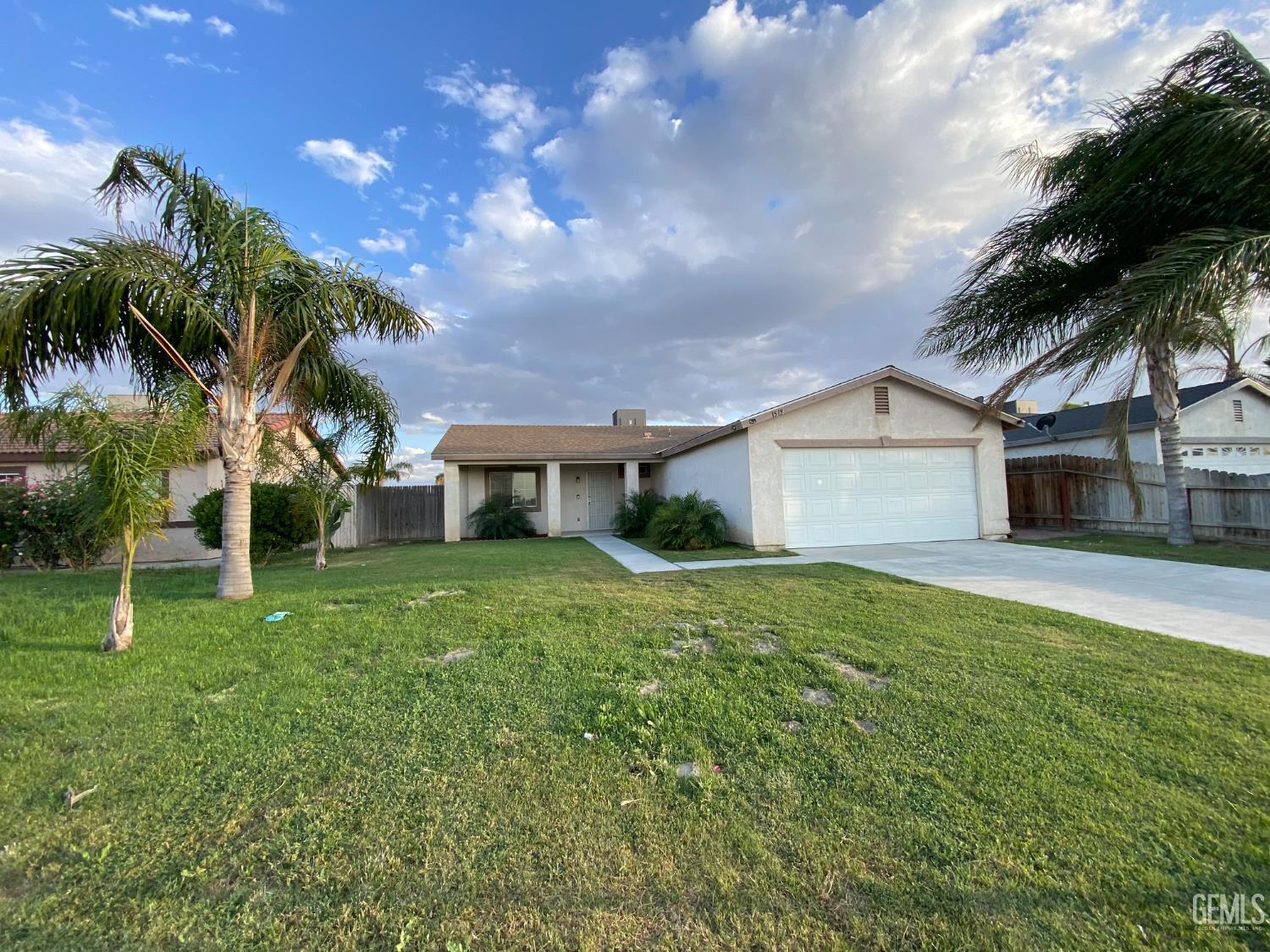Undisclosed Address Bakersfield, CA 93307 - Photo 3 of 34 a front view of a house with a yard and trees