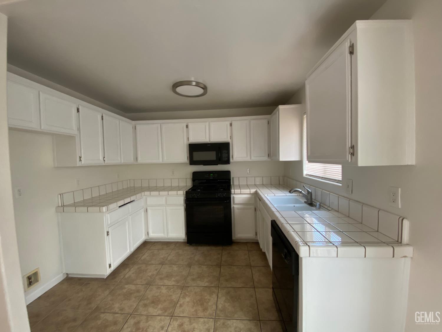 Undisclosed Address Bakersfield, CA 93307 - Photo 9 of 34 a kitchen with a sink a stove top oven and refrigerator