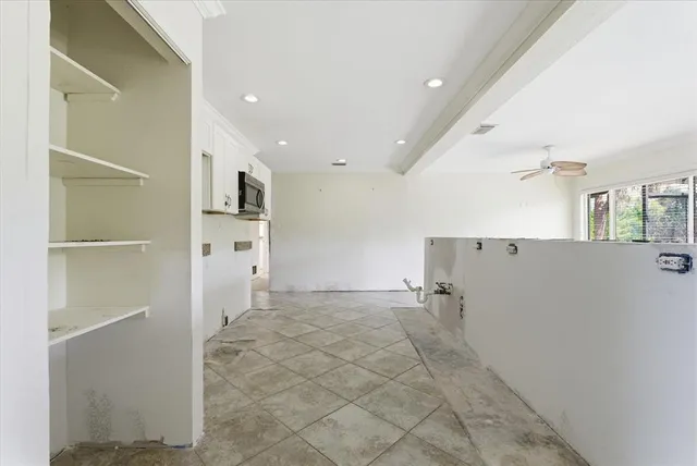 a view of a kitchen with stainless steel appliances kitchen island granite countertop a refrigerator and microwave
