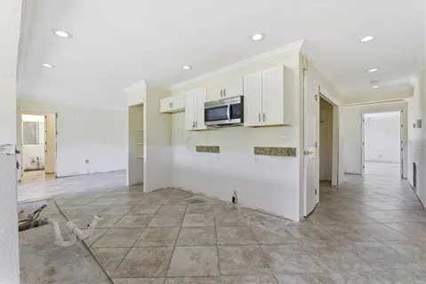 a view of an empty room with a window and a chandelier fan