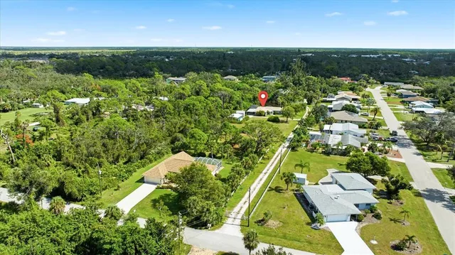 an aerial view of residential houses with outdoor space and trees