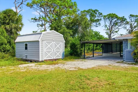 a view of a house with a backyard and a tree