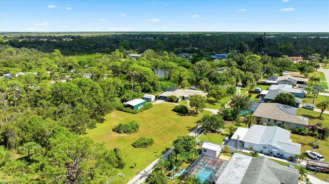 an aerial view of residential houses with outdoor space and trees
