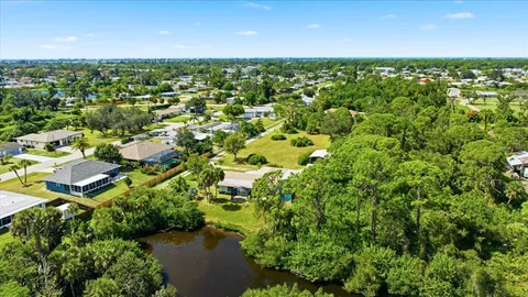 an aerial view of residential houses with outdoor space and trees