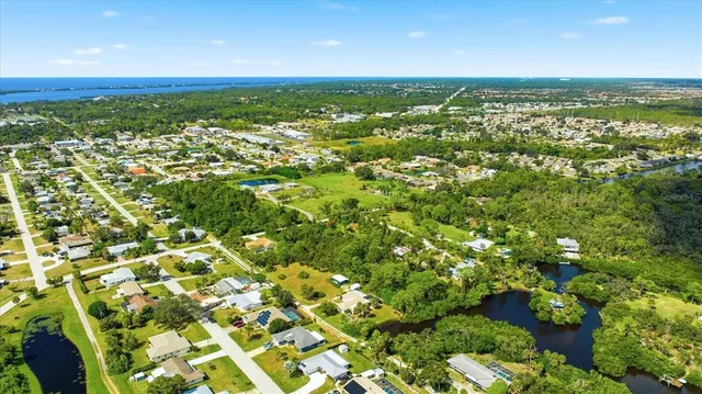 an aerial view of residential houses with outdoor space and trees