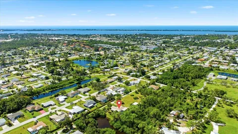 an aerial view of residential houses with outdoor space and trees