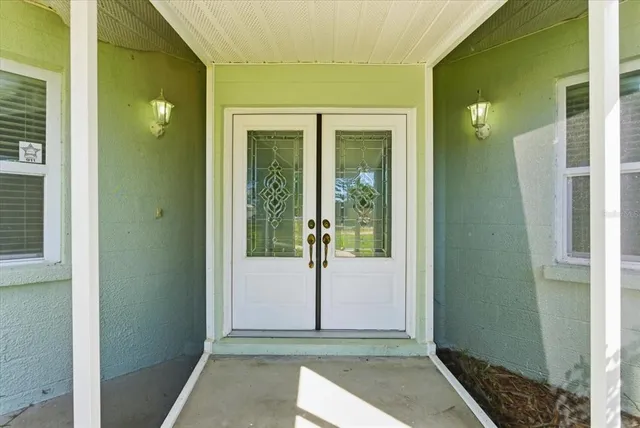 a view of a hallway with wooden floor and a glass door