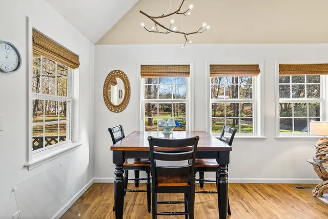a dining room with wooden floor a glass table and chairs