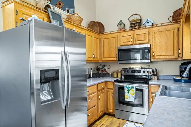 a kitchen with stainless steel appliances granite countertop a refrigerator a stove top oven a sink and dishwasher