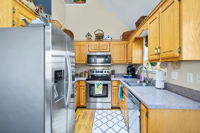 a kitchen with stainless steel appliances granite countertop a stove a sink and a microwave