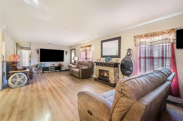 a living room with furniture a flat screen tv and a window