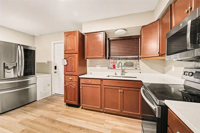 a kitchen with stainless steel appliances granite countertop a sink stove and refrigerator