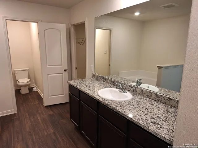 a bathroom with a granite countertop sink and a mirror