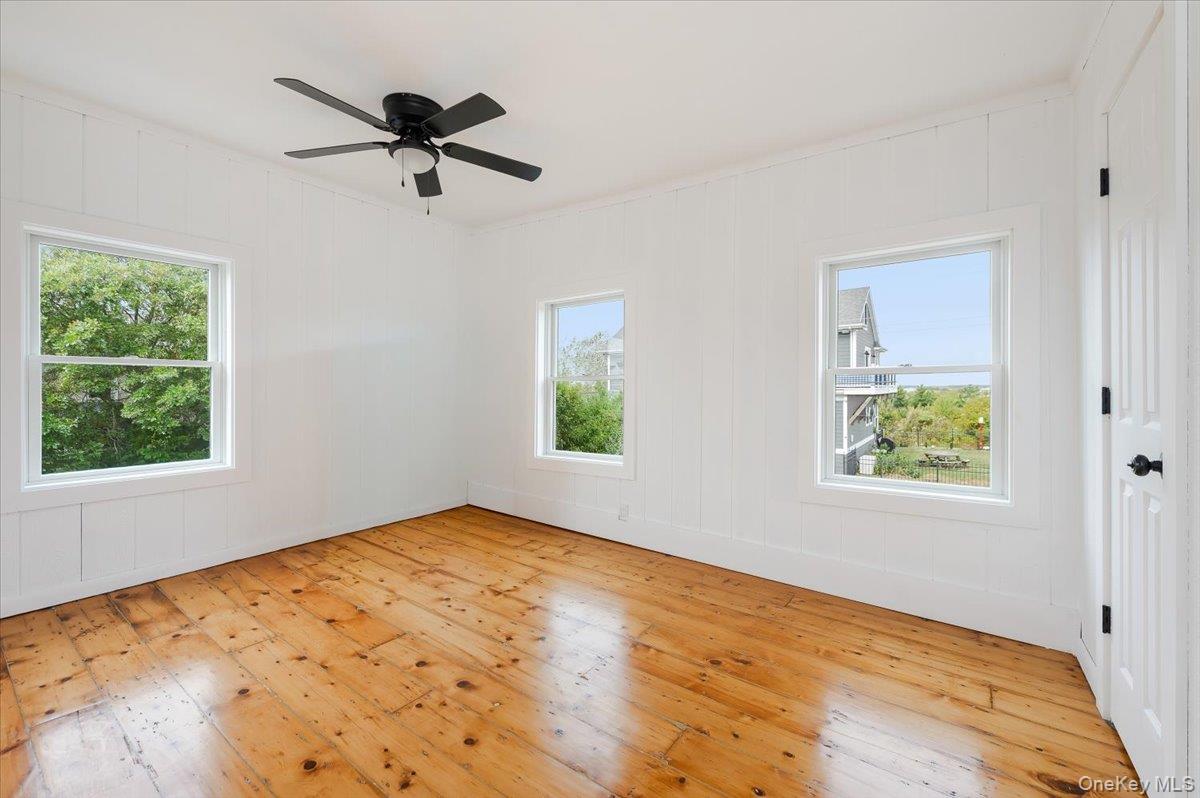 56 Oak Beach Road Babylon, NY 11702 - Photo 18 of 30 Primary bedroom with original refinished wide plank hardwood floors and new Anderson windows.