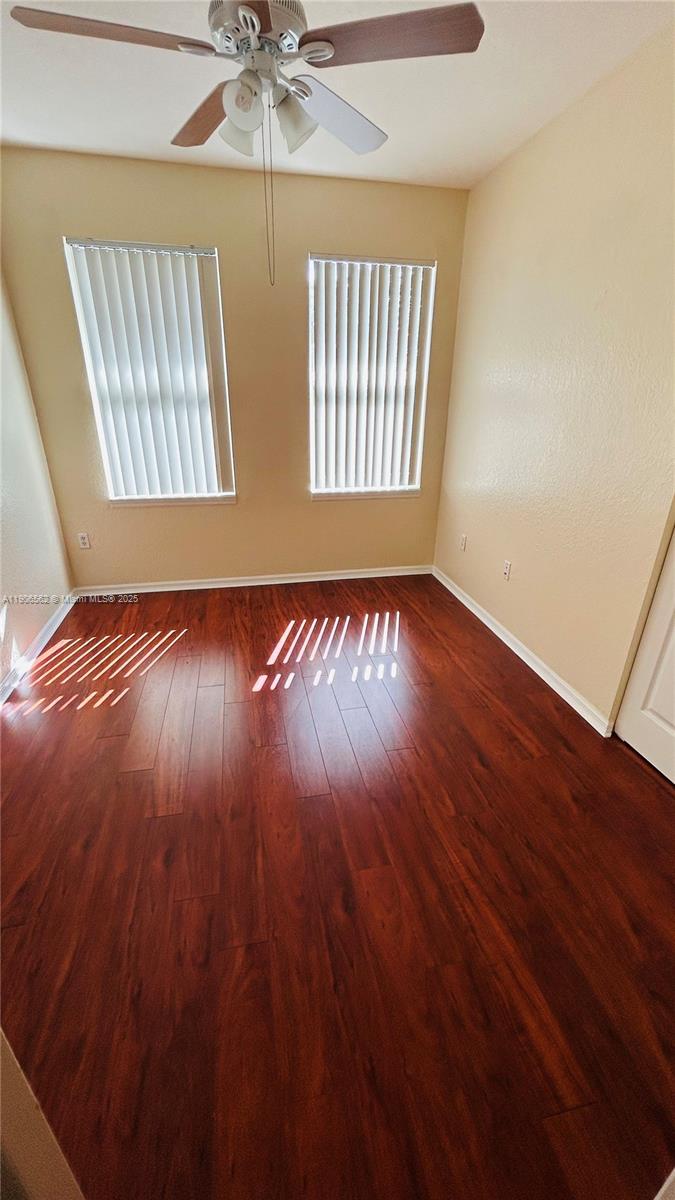 6732 West Sample Road, Unit 6732 Coral Springs, FL 33067 - Photo 17 of 25 an empty room with wooden floor fan and windows