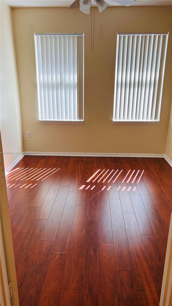 6732 West Sample Road, Unit 6732 Coral Springs, FL 33067 - Photo 19 of 25 an empty room with wooden floor and windows