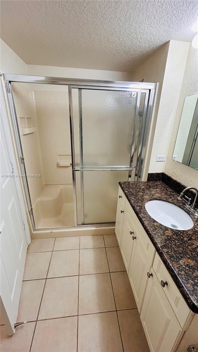 6732 West Sample Road, Unit 6732 Coral Springs, FL 33067 - Photo 21 of 25 a bathroom with a granite countertop sink a mirror and shower