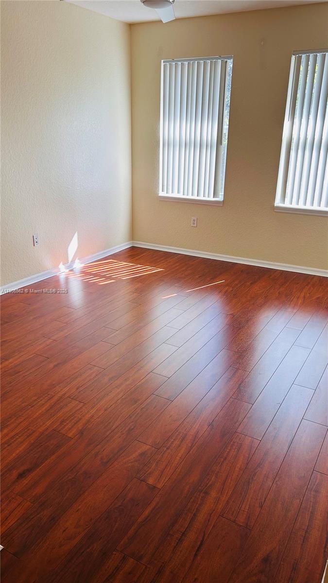 6732 West Sample Road, Unit 6732 Coral Springs, FL 33067 - Photo 23 of 25 an empty room with wooden floor and windows