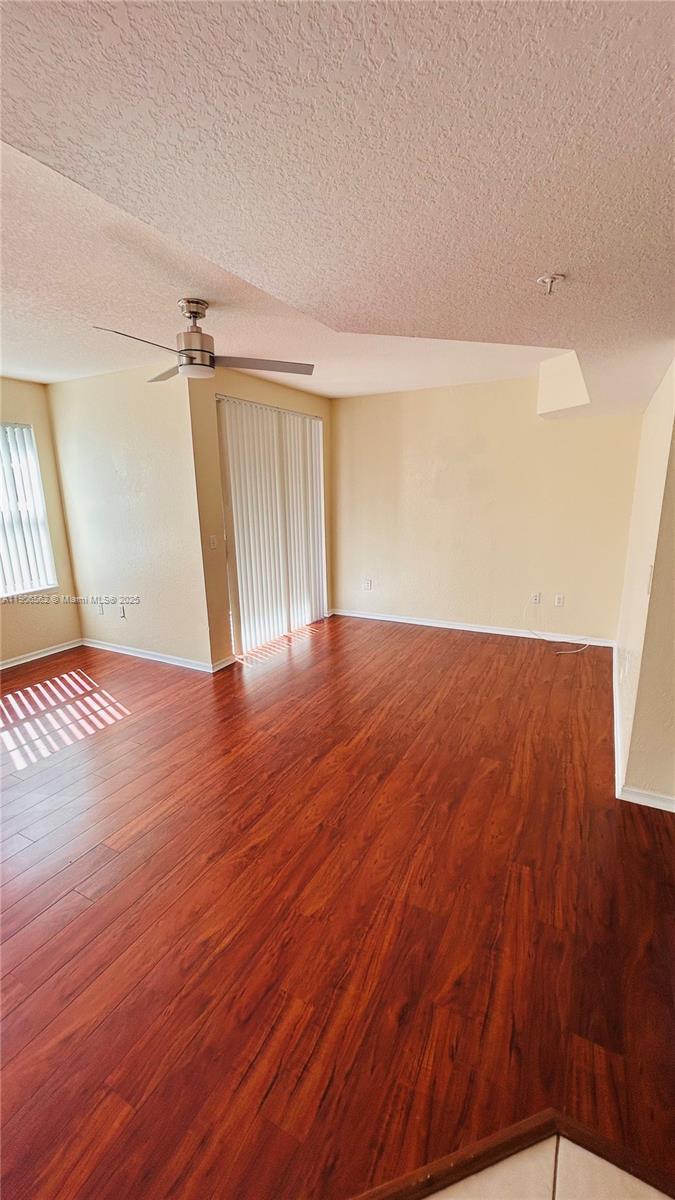 6732 West Sample Road, Unit 6732 Coral Springs, FL 33067 - Photo 7 of 25 an empty room with wooden floor and windows