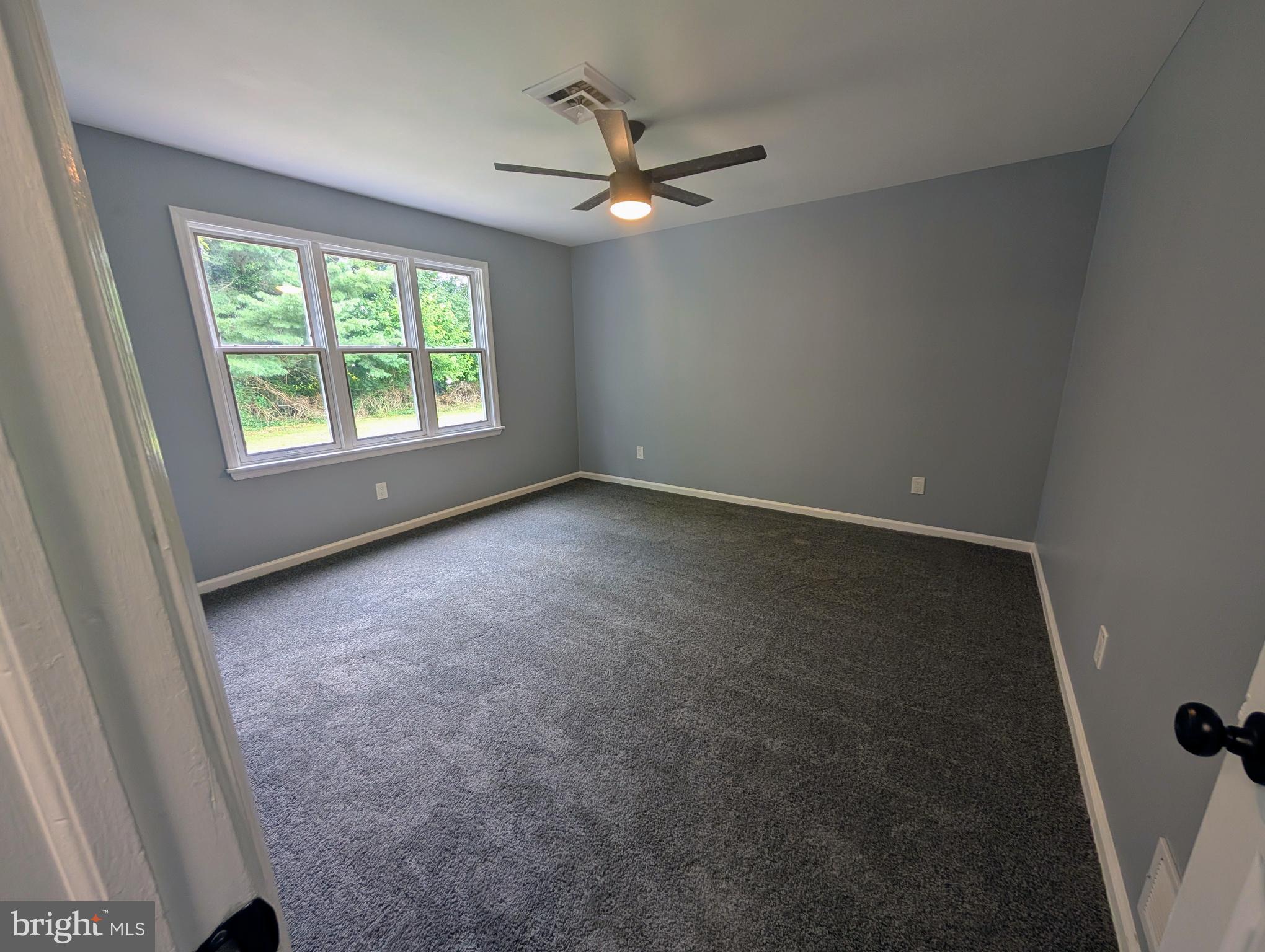 1037 Queens Road Vineland, NJ 08361 - Photo 32 of 40 an empty room with a ceiling fan and window
