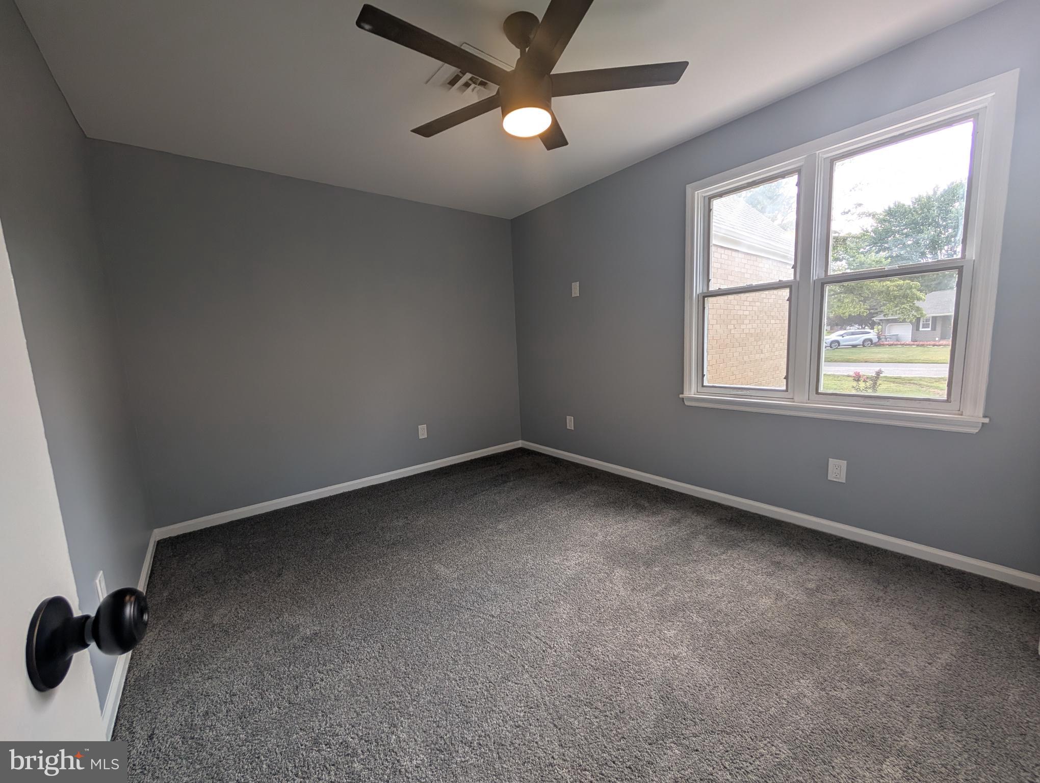 1037 Queens Road Vineland, NJ 08361 - Photo 33 of 40 an empty room with a ceiling fan and window