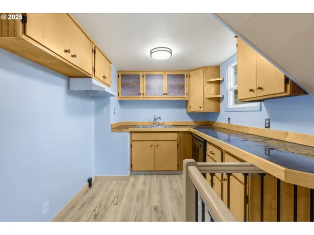a kitchen with a sink cabinets and wooden floor