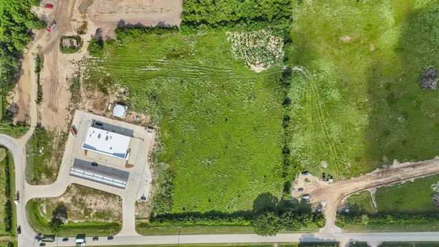 an aerial view of residential houses with outdoor space and trees