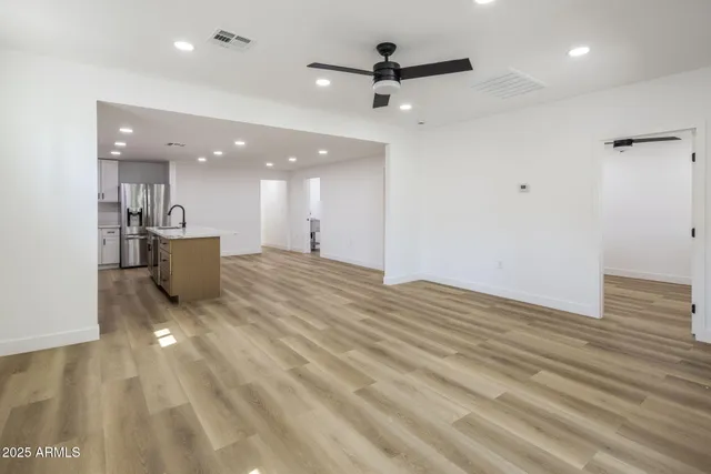 a view of a living room a ceiling fan and kitchen view