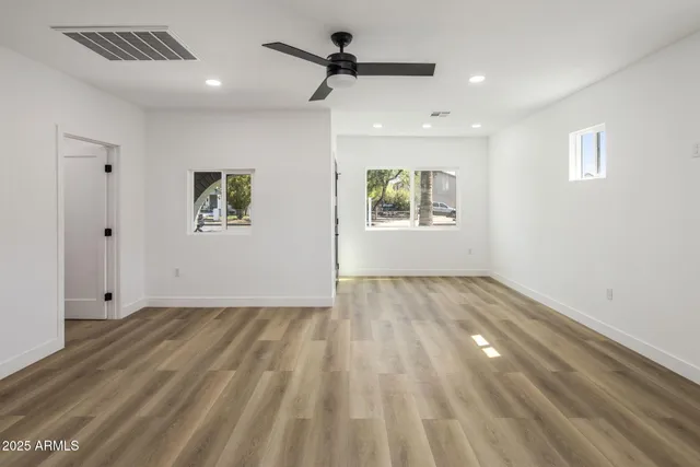 a view of empty room with wooden floor