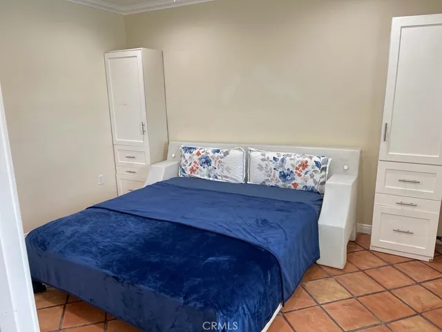a bed sitting in a bedroom next to a cabinet