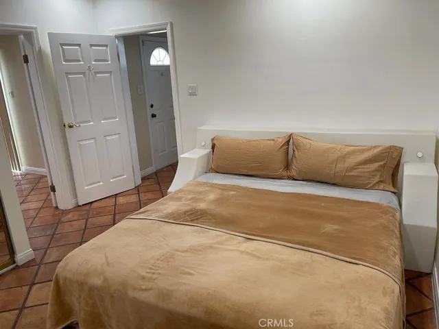 a bedroom with a bed and hardwood floor