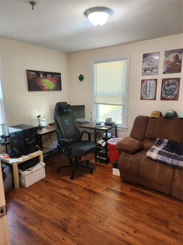 a living room with furniture a flat screen tv and a window
