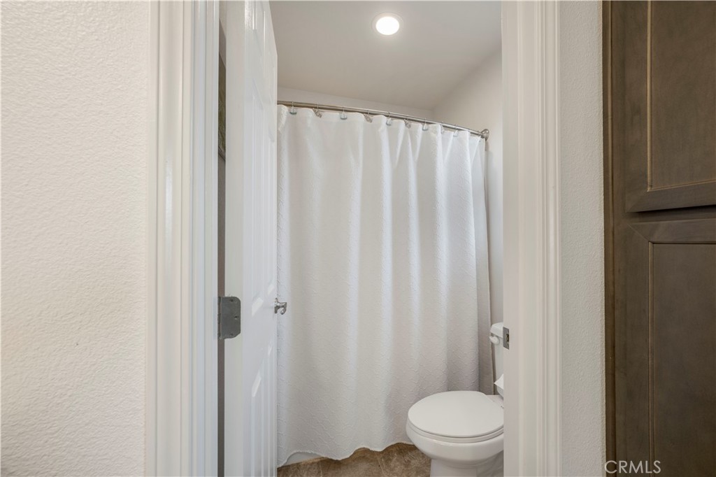 4368 Ladera Drive Guadalupe, CA 93434 - Photo 18 of 39 a white toilet sitting next to a shower curtain