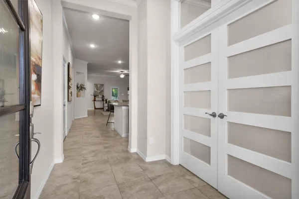 a view of a hallway with wooden floor and windows