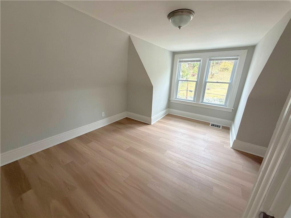 589 5th Street, Unit 2 Pitcairn, PA 15140 - Photo 2 of 6 an empty room with wooden floor and windows