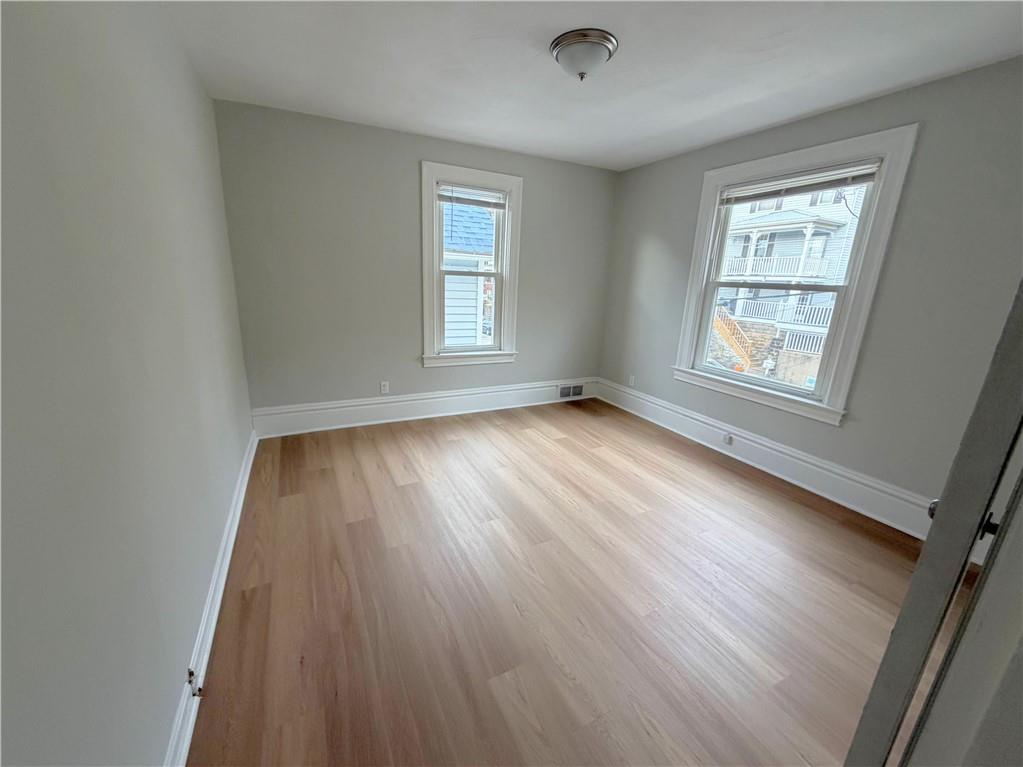 589 5th Street, Unit 2 Pitcairn, PA 15140 - Photo 3 of 6 an empty room with wooden floor and windows