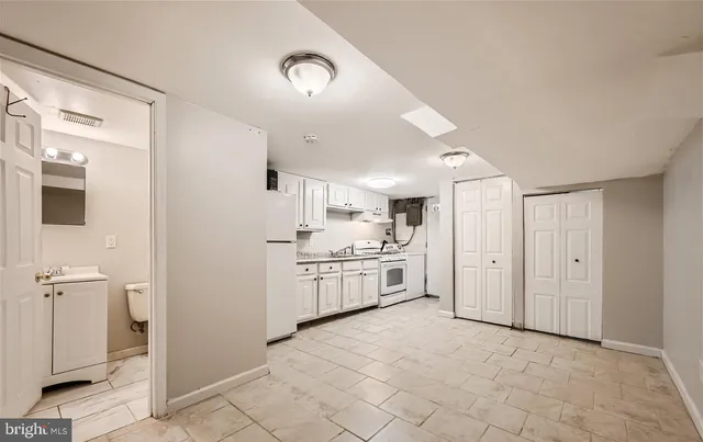 a kitchen with white cabinets and white appliances