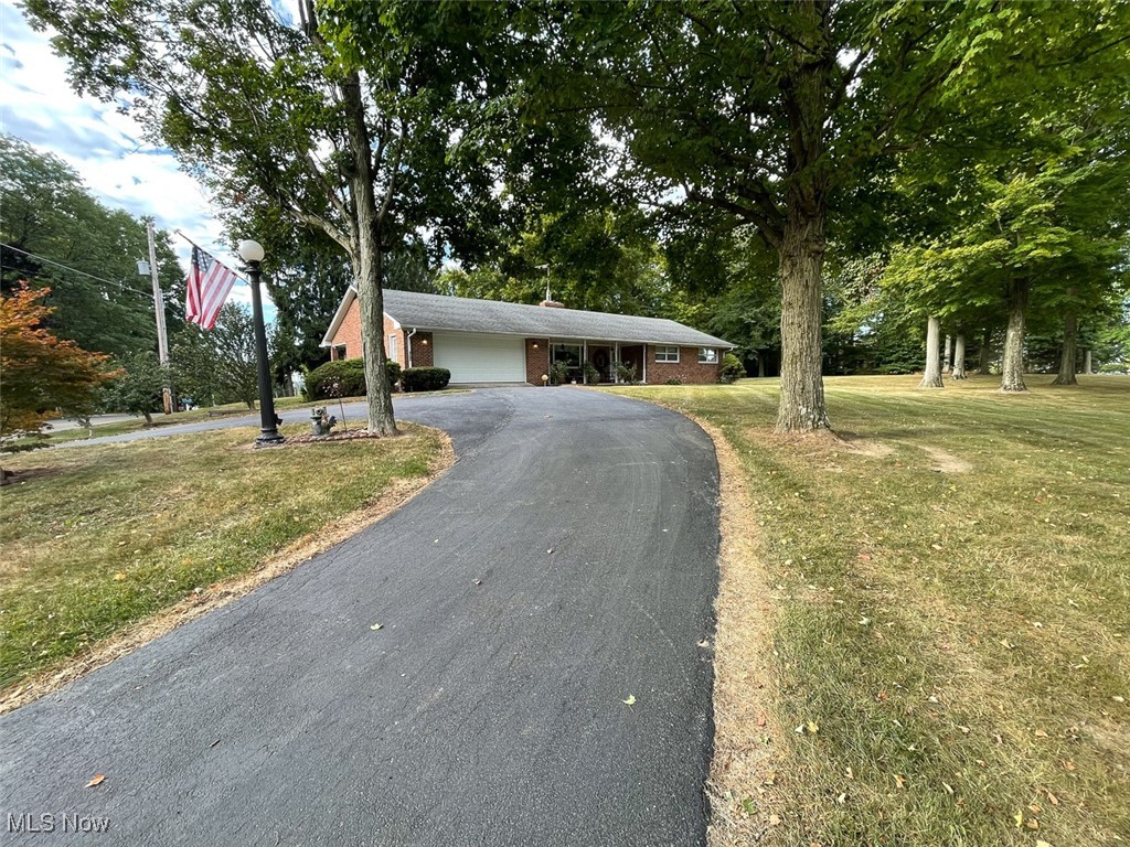 5990 Meese Road Northeast Louisville, OH 44641 - Photo 2 of 16 Ranch-style house featuring brick siding, driveway, an attached garage, and a front yard
