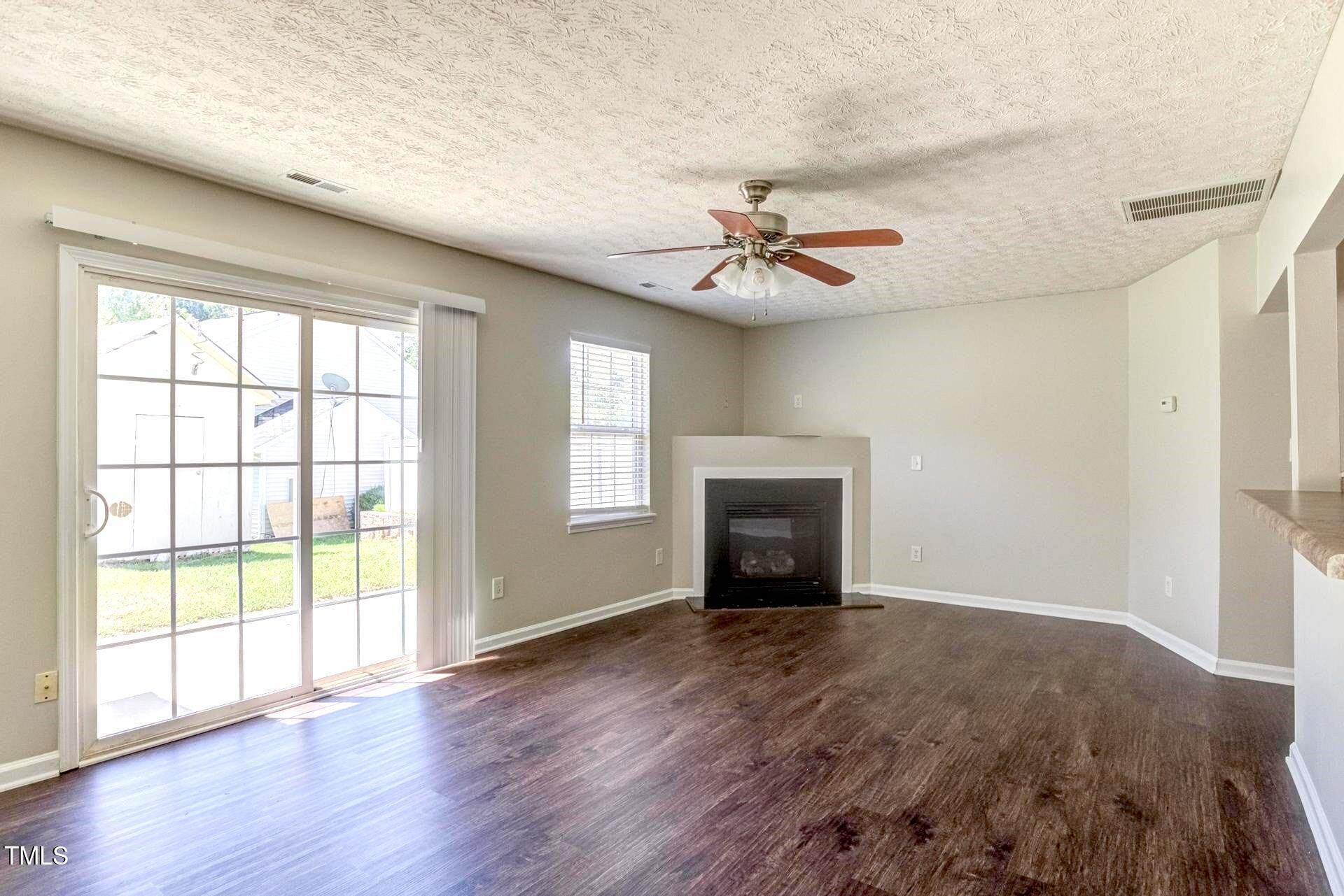 4 Intrepid Court Durham, NC 27703 - Photo 8 of 25 a view of an empty room with wooden floor and a window