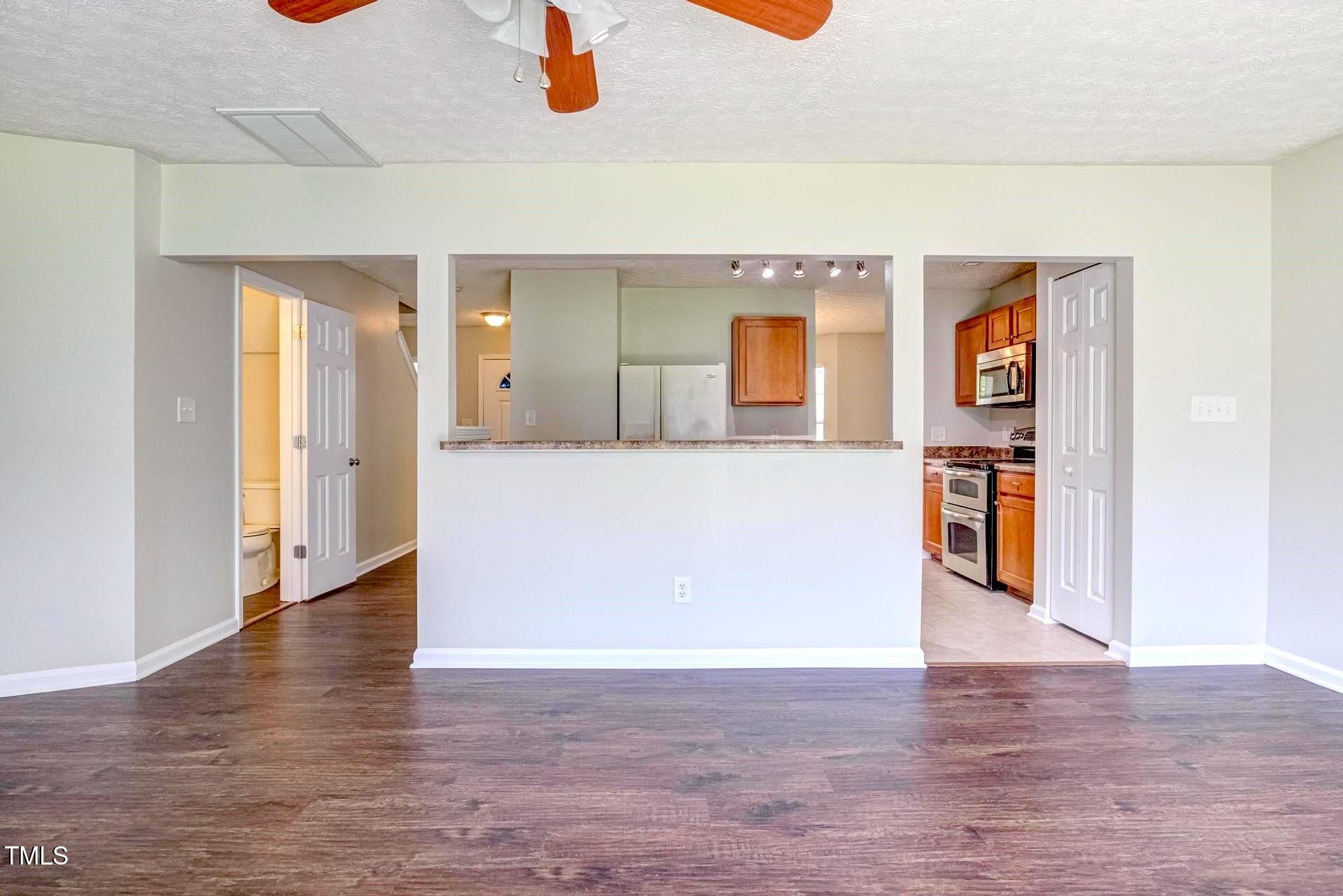 4 Intrepid Court Durham, NC 27703 - Photo 10 of 25 a view of a kitchen with a fridge and wooden floor