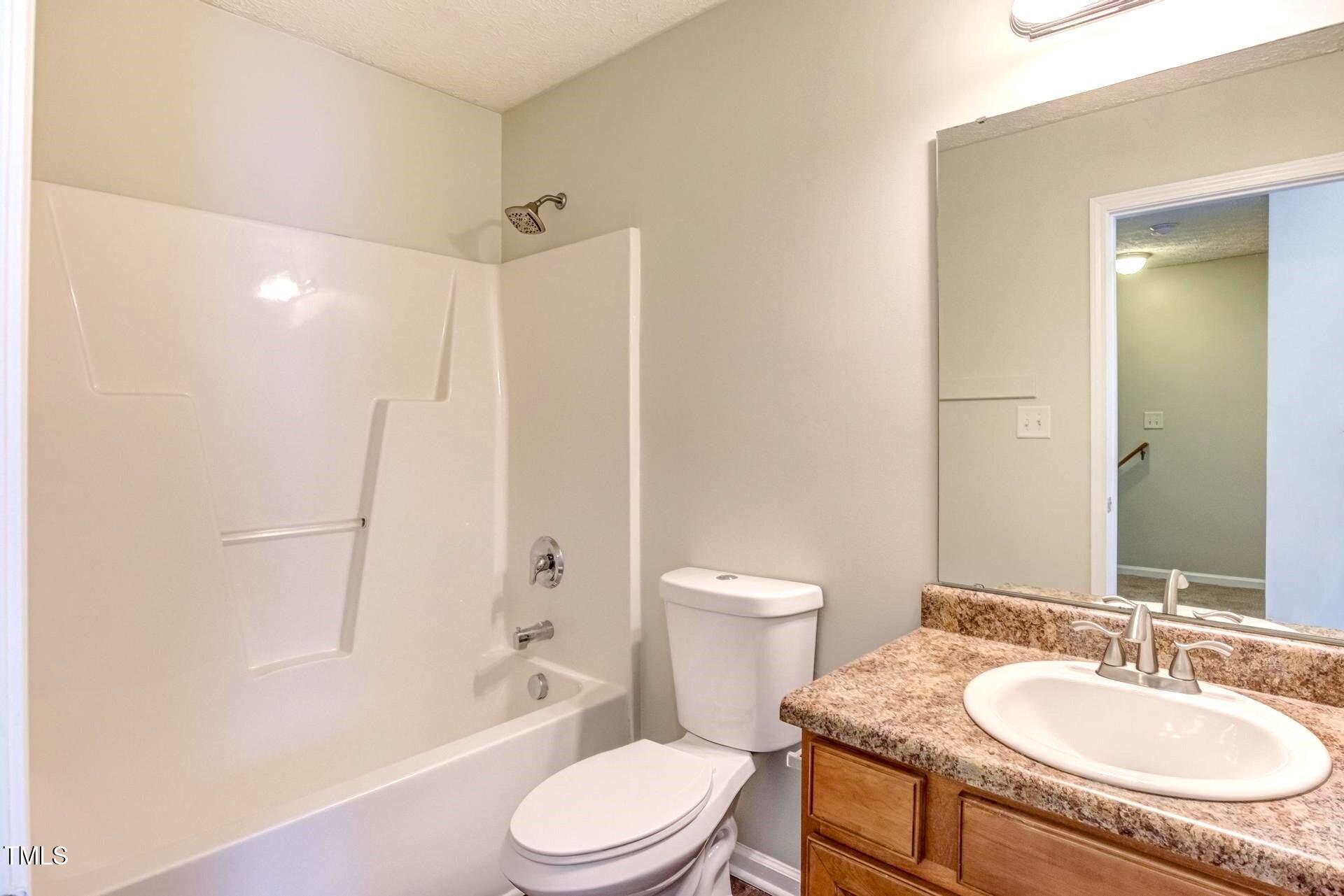 4 Intrepid Court Durham, NC 27703 - Photo 17 of 25 a bathroom with a granite countertop toilet sink and shower