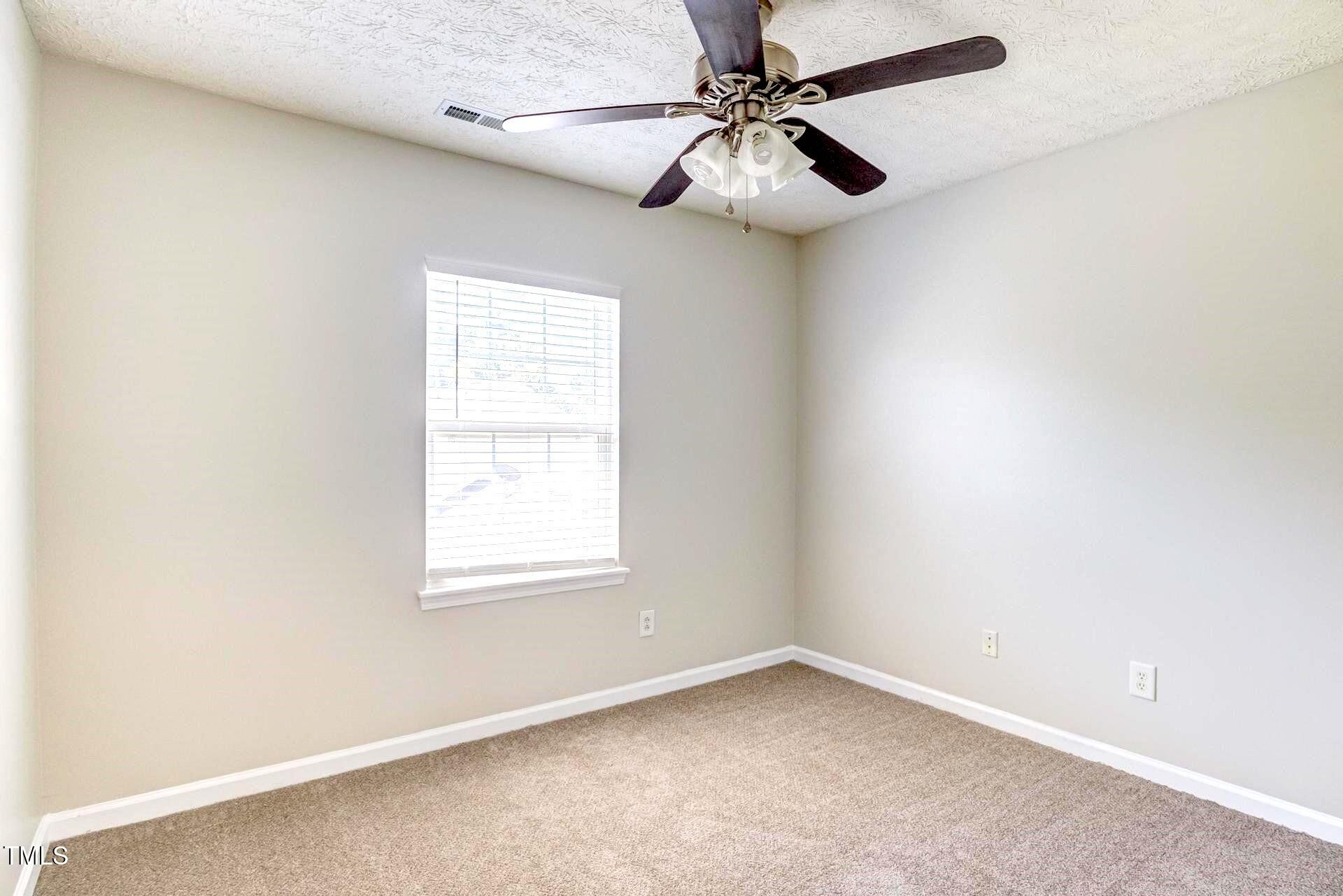 4 Intrepid Court Durham, NC 27703 - Photo 18 of 25 an empty room with a window and a fan