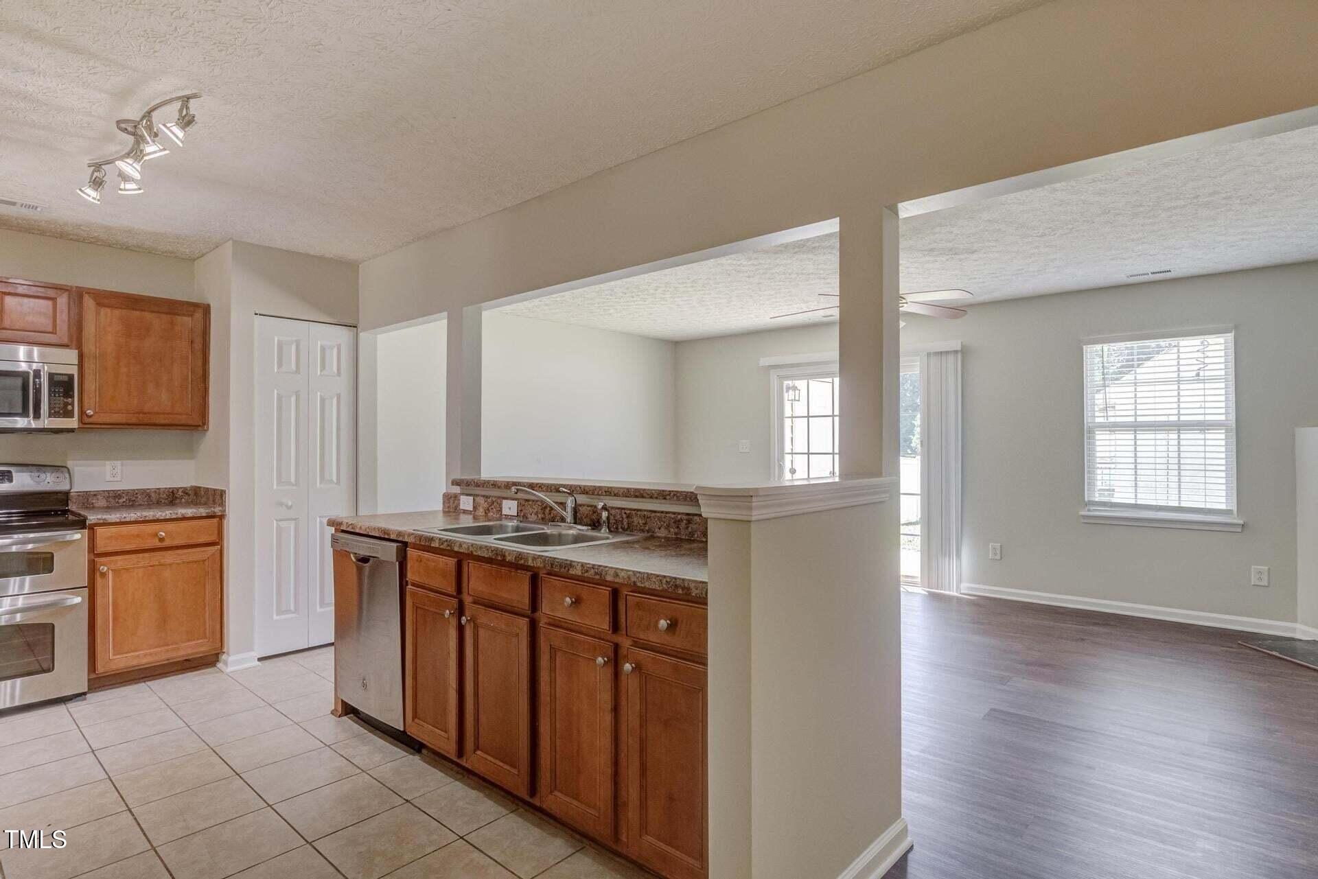 4 Intrepid Court Durham, NC 27703 - Photo 5 of 25 a kitchen with stainless steel appliances granite countertop a stove and a sink