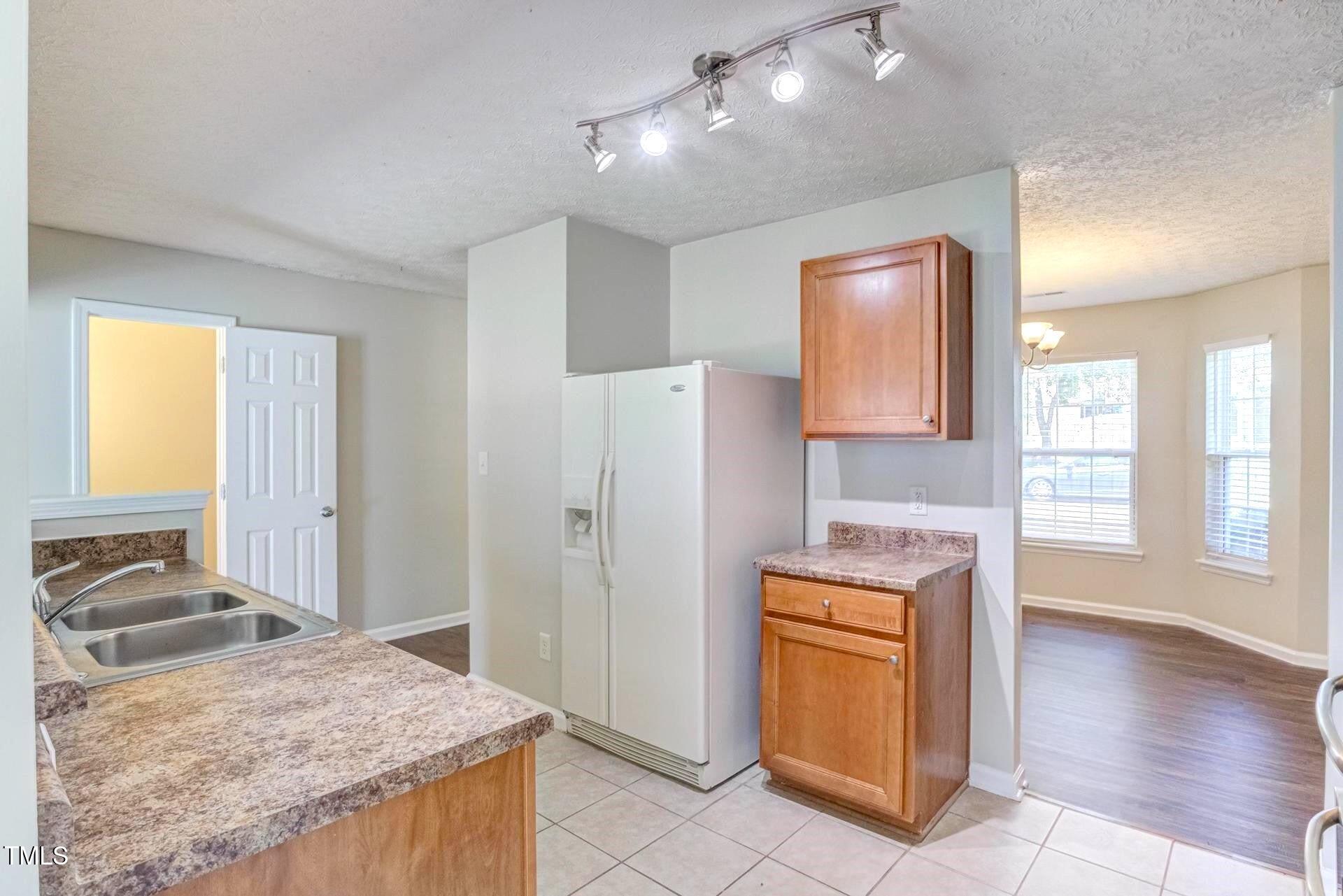 4 Intrepid Court Durham, NC 27703 - Photo 6 of 25 a view of a kitchen with a sink dishwasher and wooden cabinets